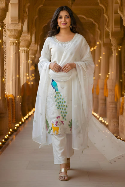 Woman in a white traditional outfit standing in an ornate corridor with arches and string lights.