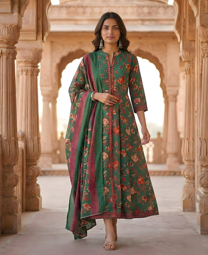 Woman in a green floral dress standing in an architectural setting with intricate carvings.